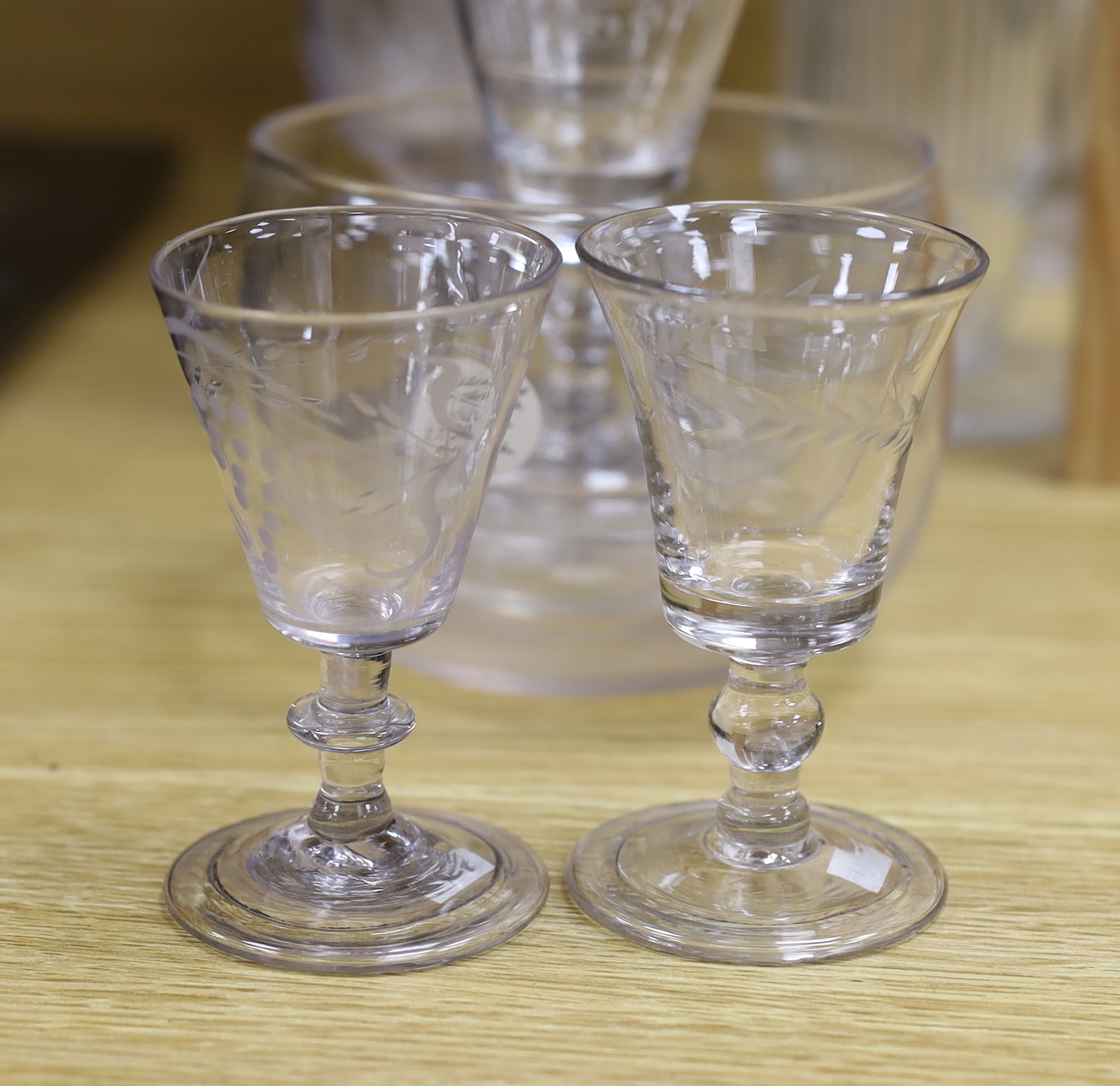 A collection of 18th and 19th century drinking glasses, etc. including rummers, engraved sherry glasses with knobbed stems, folded feet and broken pontils, a cut glass goblet, a Georgian finger bowl and stand, two vases,